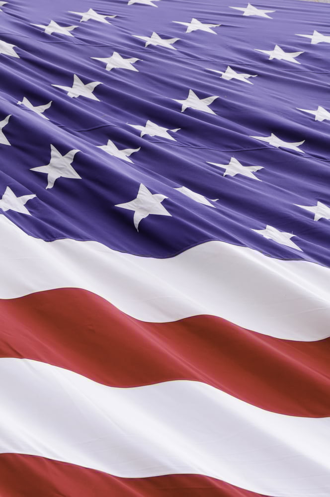 Vertical section of windblown American flag with undulating stripes and diagonal ripples like schisms among stars Vertical section of windblown American flag with undulating stripes and diagonal ripples like schisms among stars